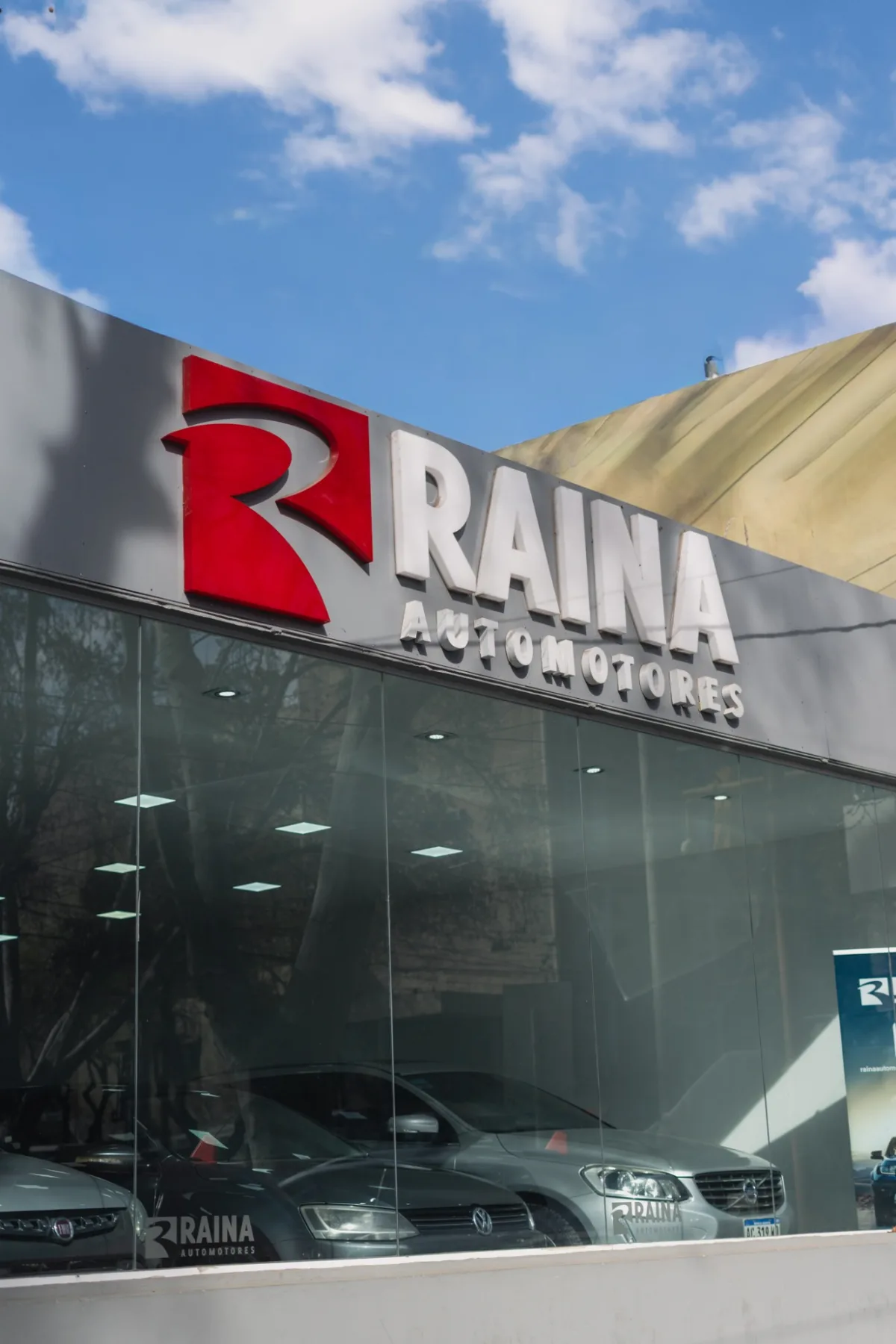 Cartel de Raina Automotores sobre la vidriera del salón