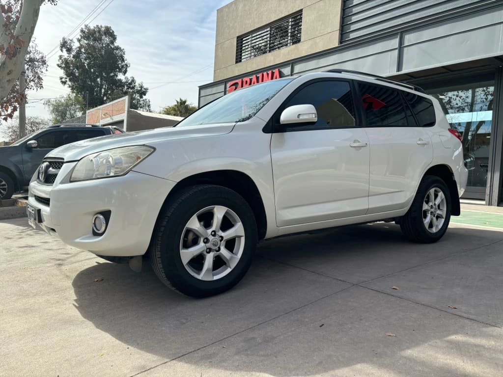 Toyota RAV4 gris plata frente a una sucursal de Raina Automotores